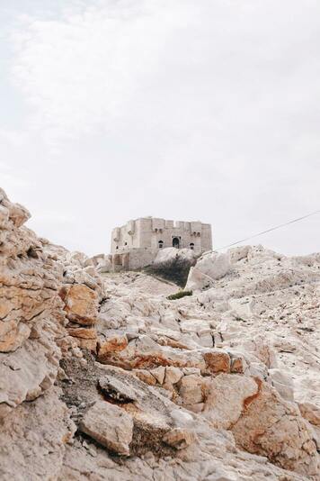 Photographie en plein jour du Fort de Pomègues, dans un enrironnement rocailleux et aride.